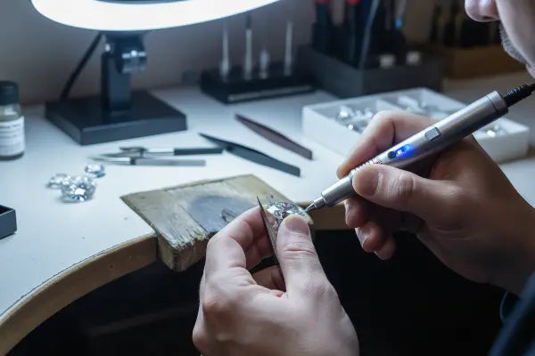 Jeweler's hand crafting diamond